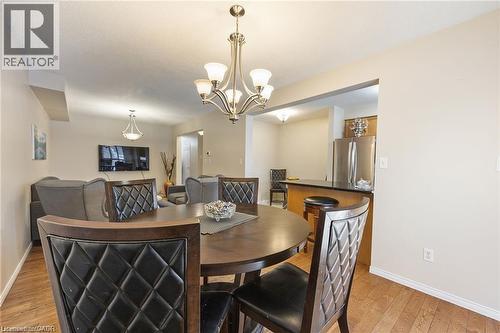 Open-concept living space featuring wood-finish flooring, a contemporary chandelier, and recessed lighting - 125 Terni Boulevard, Hamilton, ON 