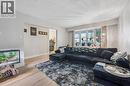 Expansive living area featuring a large bay window, recessed wall opening, light wood-finish flooring, and white baseboards - 35 Vicmount Drive, Kitchener, ON 
