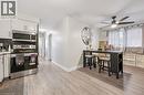 Contemporary kitchen featuring white cabinetry, stainless steel appliances, and wood-finish flooring - 35 Vicmount Drive, Kitchener, ON 