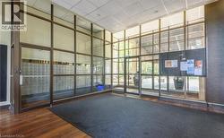 Lobby entrance featuring expansive glass paneling, wood-finish flooring, and a bank of individual mailboxes - 