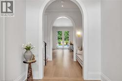 Archway entry featuring light wood-finish flooring, recessed lighting, and white trim - 