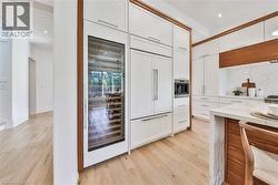 Gourmet kitchen with integrated appliances, including a built-in wine refrigerator and coffee system - 