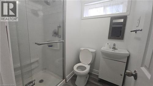 Bathroom featuring a glass-enclosed shower, white subway tile surround, and a wall-mounted showerhead - 58 Belwood Crescent, Kitchener, ON 