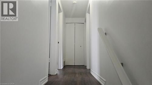 Hallway featuring wood-finish flooring, white walls, and bright white trim - 58 Belwood Crescent, Kitchener, ON 