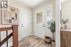 Entryway featuring a white front door with decorative glass inserts and an adjacent sidelight - 