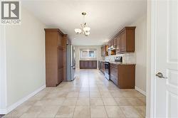 Spacious kitchen featuring extensive wood cabinetry, stainless steel appliances, granite countertops, and a tiled backsplash - 