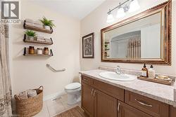 Bathroom featuring a single vanity with an integrated sink, a speckled countertop, and a wood-finish cabinet - 
