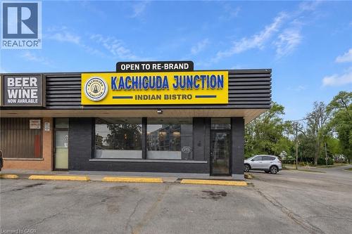 Commercial storefront with ample parking, prominent signage, expansive front windows, and a dedicated entrance - 155 Highland Road E, Kitchener, ON 