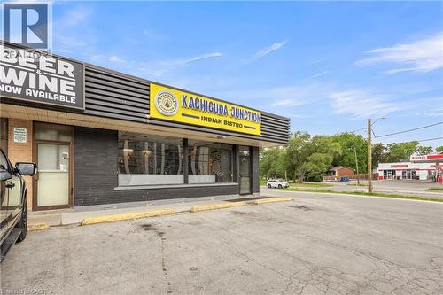 Commercial building featuring a brick facade with horizontal paneling and prominent storefront windows - 155 Highland Road E, Kitchener, ON 