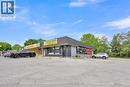 Commercial building featuring a dark exterior facade with contrasting yellow signage - 155 Highland Road E, Kitchener, ON 