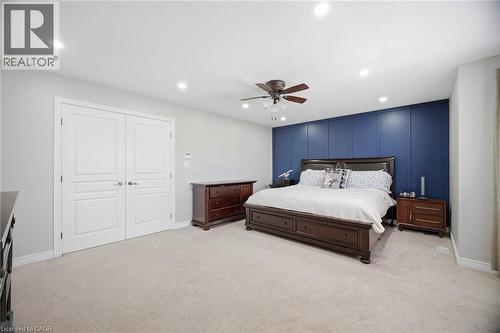 Spacious room featuring light gray walls, a blue accent wall with vertical paneling, recessed lighting, a ceiling fan with integrated lighting, and carpet flooring - 79 Garinger Crescent, Hamilton, ON 