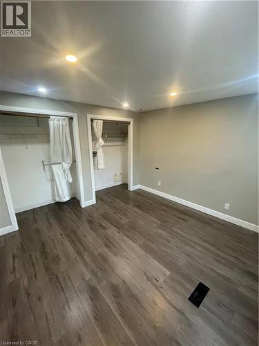 Spacious room featuring wood-finish flooring, recessed lighting, and two open closet spaces with hanging rods - 134 Bridgeport Road E Unit# Upper, Waterloo, ON 