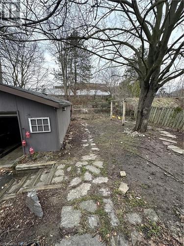 Expansive outdoor area featuring a stone pathway, a mature tree, and a detached shed with a window - 134 Bridgeport Road E Unit# Upper, Waterloo, ON 