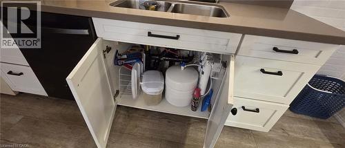 White shaker-style cabinetry featuring black hardware, a double basin stainless steel sink, and a dark countertop - 134 Bridgeport Road E Unit# Upper, Waterloo, ON 