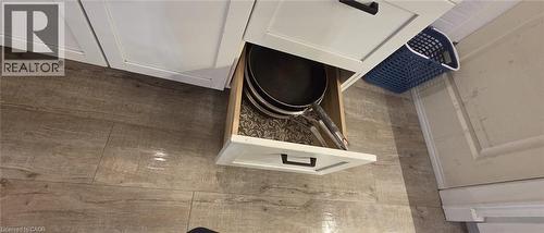 White cabinetry featuring matte black hardware, wood-finish flooring, and a base cabinet drawer - 134 Bridgeport Road E Unit# Upper, Waterloo, ON 