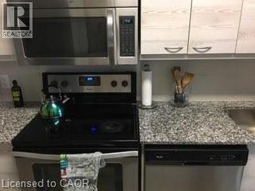 Kitchen featuring stainless steel appliances, speckled stone countertops, and light wood-finish cabinetry - 280 Lester Street Unit# 607, Waterloo, ON 