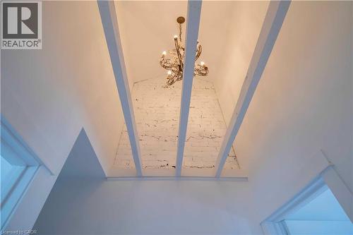 Vaulted ceiling featuring exposed white beams and a decorative chandelier - 36 Fullerton Avenue, Hamilton, ON 