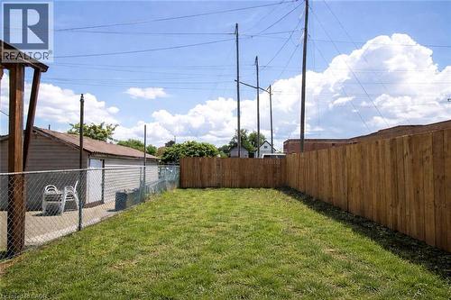 Grassed yard area featuring a wood privacy fence along one side - 36 Fullerton Avenue, Hamilton, ON 