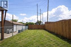 Grassed yard area featuring a wood privacy fence along one side - 