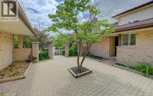 Exterior entry court featuring a patterned paver surface, brick facade, and integrated landscaping beds - 458 Beechwood Place Unit# 3, Waterloo, ON - Outdoor With Exterior