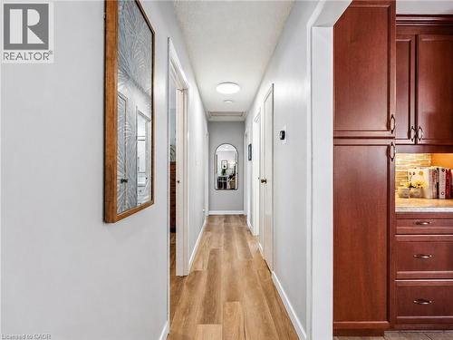 Hallway featuring wood-finish flooring, light grey wall paint, and recessed ceiling lighting - 2 Keewatin Avenue, Kitchener, ON 