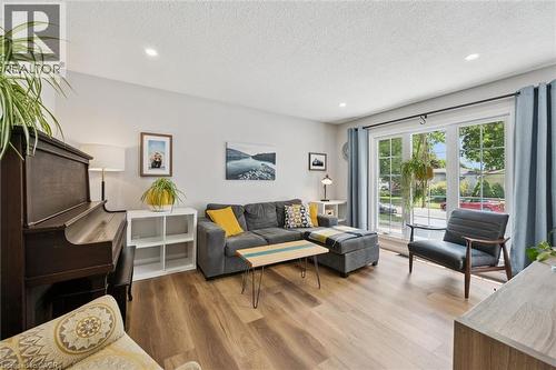 Spacious interior featuring wood-finish flooring, recessed lighting, and a large window with white framing - 2 Keewatin Avenue, Kitchener, ON 