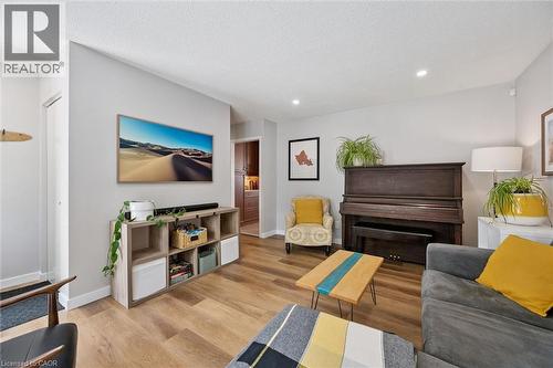 Living area featuring wood-finish flooring, light grey painted walls, and recessed lighting - 2 Keewatin Avenue, Kitchener, ON 
