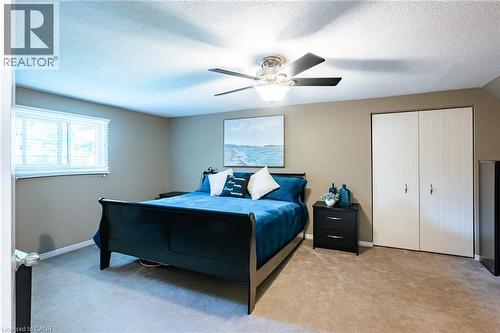 Spacious room featuring neutral wall tones, carpet flooring, a window with blinds, and white bi-fold closet doors - 28 Mcgibbon Court, Kitchener, ON 