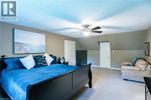 Carpeted room featuring a ceiling fan with integrated lighting, sloped ceilings, and neutral wall tones - 28 Mcgibbon Court, Kitchener, ON 