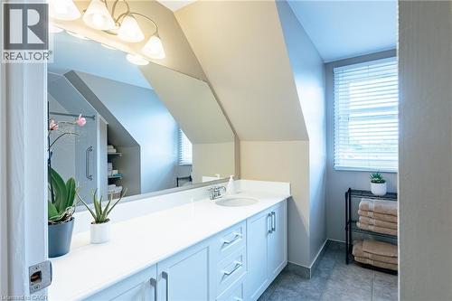Bathroom featuring a white vanity with integrated sink, a large wall-mounted mirror, and tile flooring - 28 Mcgibbon Court, Kitchener, ON 