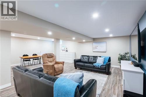 Spacious finished basement featuring wood-finish flooring, recessed lighting, and light-toned walls - 28 Mcgibbon Court, Kitchener, ON 