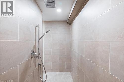 Tiled shower enclosure featuring a ceiling-mounted rainfall showerhead, a handheld shower fixture, and recessed lighting - 28 Mcgibbon Court, Kitchener, ON 