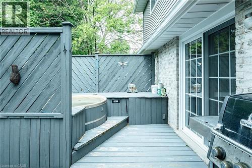 Outdoor deck featuring a built-in hot tub, privacy screening, integrated storage, and direct access to interior spaces via sliding glass doors - 28 Mcgibbon Court, Kitchener, ON 