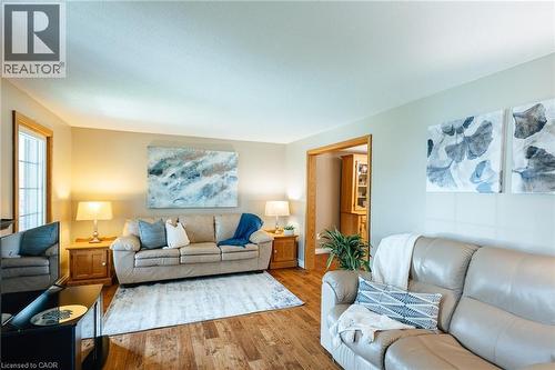 Spacious living area featuring wood-finish flooring and a neutral color palette - 28 Mcgibbon Court, Kitchener, ON 