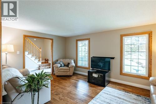 Hardwood-finish flooring spans this room featuring neutral wall tones and white trim - 28 Mcgibbon Court, Kitchener, ON 