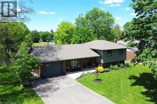 Split-level residence featuring a dark gray garage door, red brick facade, and light gray siding - 8 Sheridan Boulevard, Simcoe, ON 