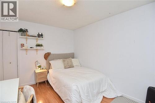 Bedroom featuring light wood-finish flooring, white walls, and a ceiling-mounted light fixture - 8 Sheridan Boulevard, Simcoe, ON 