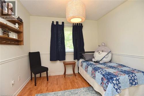 Hardwood-finish flooring complements the neutral wall color and white wainscoting - 8 Sheridan Boulevard, Simcoe, ON 