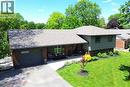Brick and siding exterior residence featuring a dark gray garage door, a covered front entry, and a paved driveway - 8 Sheridan Boulevard, Simcoe, ON 