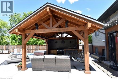 Expansive outdoor living area featuring a timber-frame gazebo with vaulted ceilings, an integrated outdoor kitchen, and a spacious concrete patio - 8 Sheridan Boulevard, Simcoe, ON 