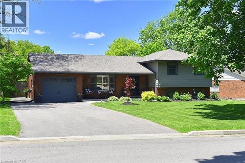 Brick and siding exterior with an attached garage, paved driveway, and mature landscaping - 8 Sheridan Boulevard, Simcoe, ON 
