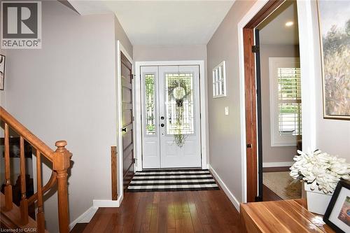 Foyer featuring wood-finish flooring and a double entry door with decorative glass inserts - 8 Sheridan Boulevard, Simcoe, ON 