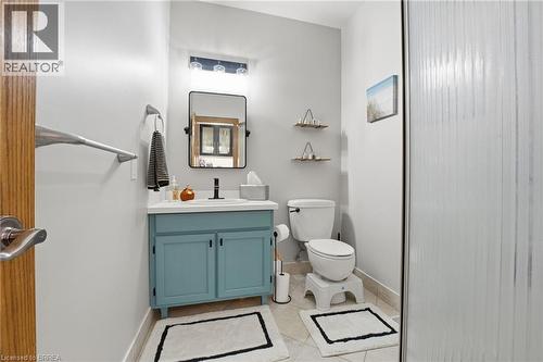 Bathroom featuring a blue painted vanity with a white countertop and a black-framed mirror - 271 Windham Rd 14, Simcoe, ON 