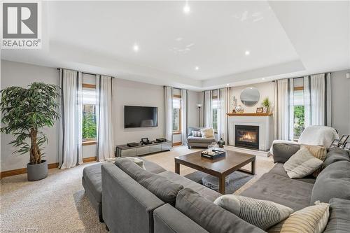 Living area featuring a gas fireplace with a white mantel, recessed lighting, crown molding, and light-toned carpeting - 271 Windham Rd 14, Simcoe, ON 