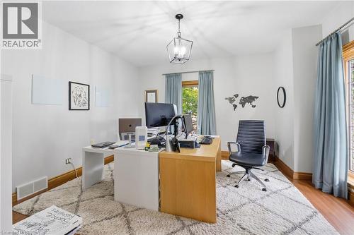 Room featuring wood-finish flooring, a textured area rug, and a central ceiling light fixture - 271 Windham Rd 14, Simcoe, ON 