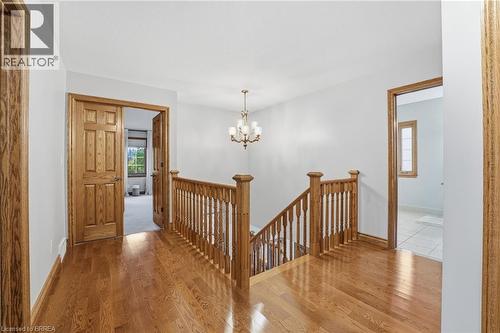 Hardwood flooring throughout the upper level hallway with natural wood trim and doors - 271 Windham Rd 14, Simcoe, ON 
