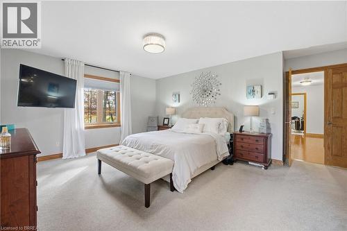 Neutral-toned wall color with light-colored carpeting, featuring a window with wood trim and white full-length drapes - 271 Windham Rd 14, Simcoe, ON 