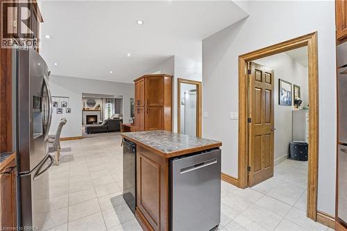 Kitchen island with integrated dishwasher, wood-finish cabinetry, and tiled flooring - 271 Windham Rd 14, Simcoe, ON 