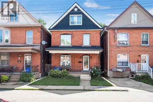 Brick exterior featuring a gabled roofline with dark siding - 38 Fairleigh Avenue N, Hamilton, ON 