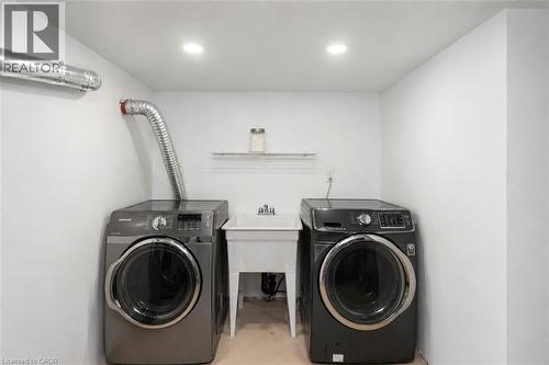 Dedicated laundry area featuring a utility sink, recessed lighting, and wall-mounted shelving - 38 Fairleigh Avenue N, Hamilton, ON 